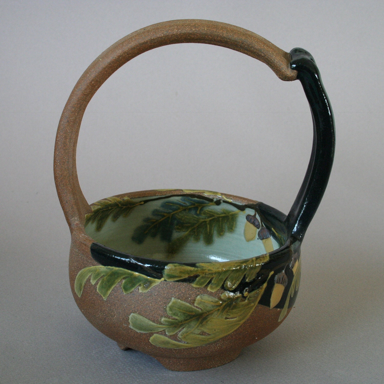 handmade stoneware basket with oak leaf motif and acorns for home decor in a Craftsman style
