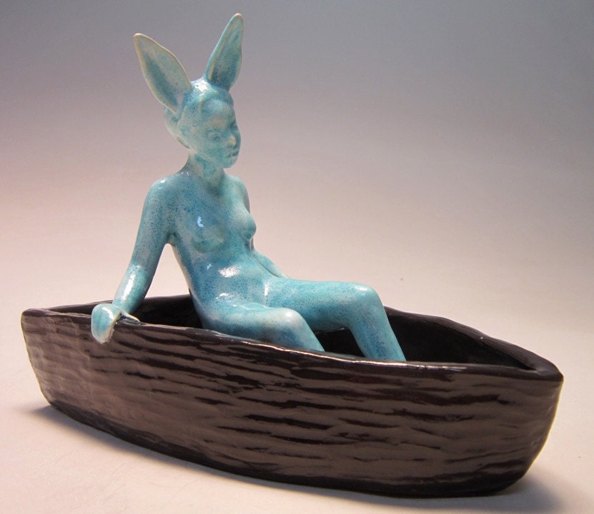 Rabbit woman drifting - figurative ceramic sculpture of blue glazed woman in brown slab constructed boat by Carrianne Hendrickson