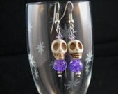 Stone Skull with purple swirly bead and purple Swarovsky crystals. sterling dangle earrings