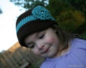 Dark brown newsboy style crochet hat with turquoise accent stripe and flower