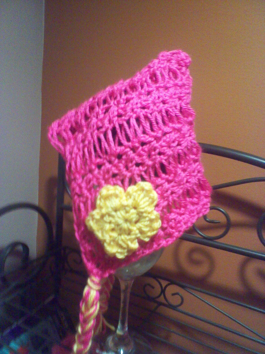 Open work crocheted baby bonnet with flower