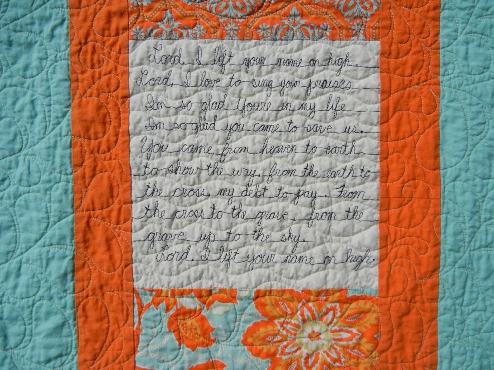 Praise Quilt with stitched words and feathers