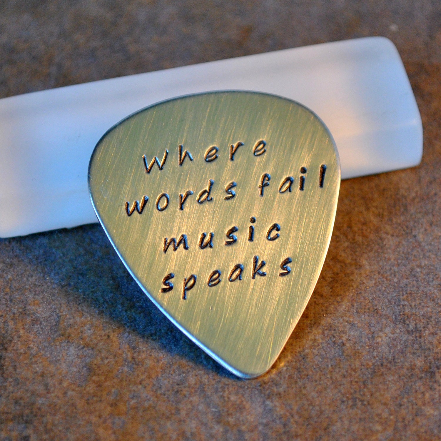 hand stamped sterling silver guitar pick - where words fail, music speaks