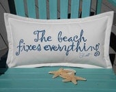The BEACH FIXES EVERYTHING  indoor outdoor pillow blue lettering on white background 12"x20" handpainted coastal tides Crabby Chris Original
