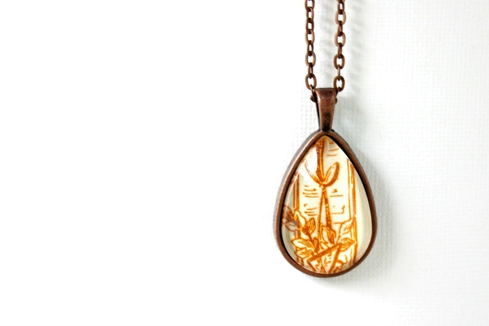 Necklace with victorian gilded age swirl flourish motif in ginger orange rust brown red from vintage sheet music under glass
