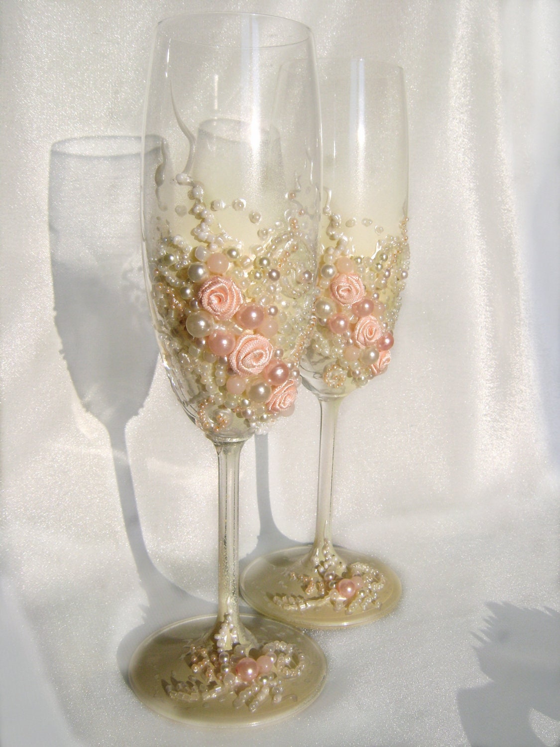 Beautiful wedding champagne glasses in blush pink and ivory, elegant toasting flutes with pearls and roses