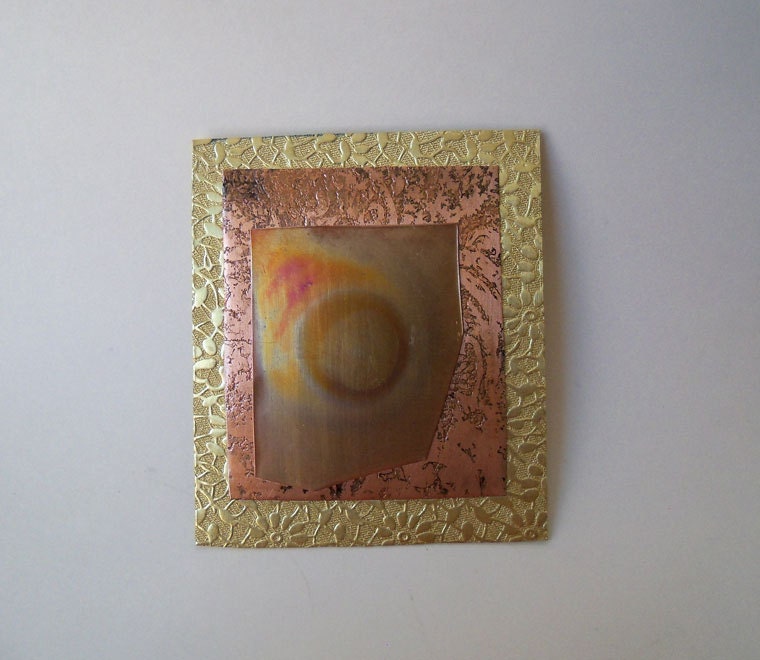 Copper brooch made from copper and brass sheet metal that was heat treated.