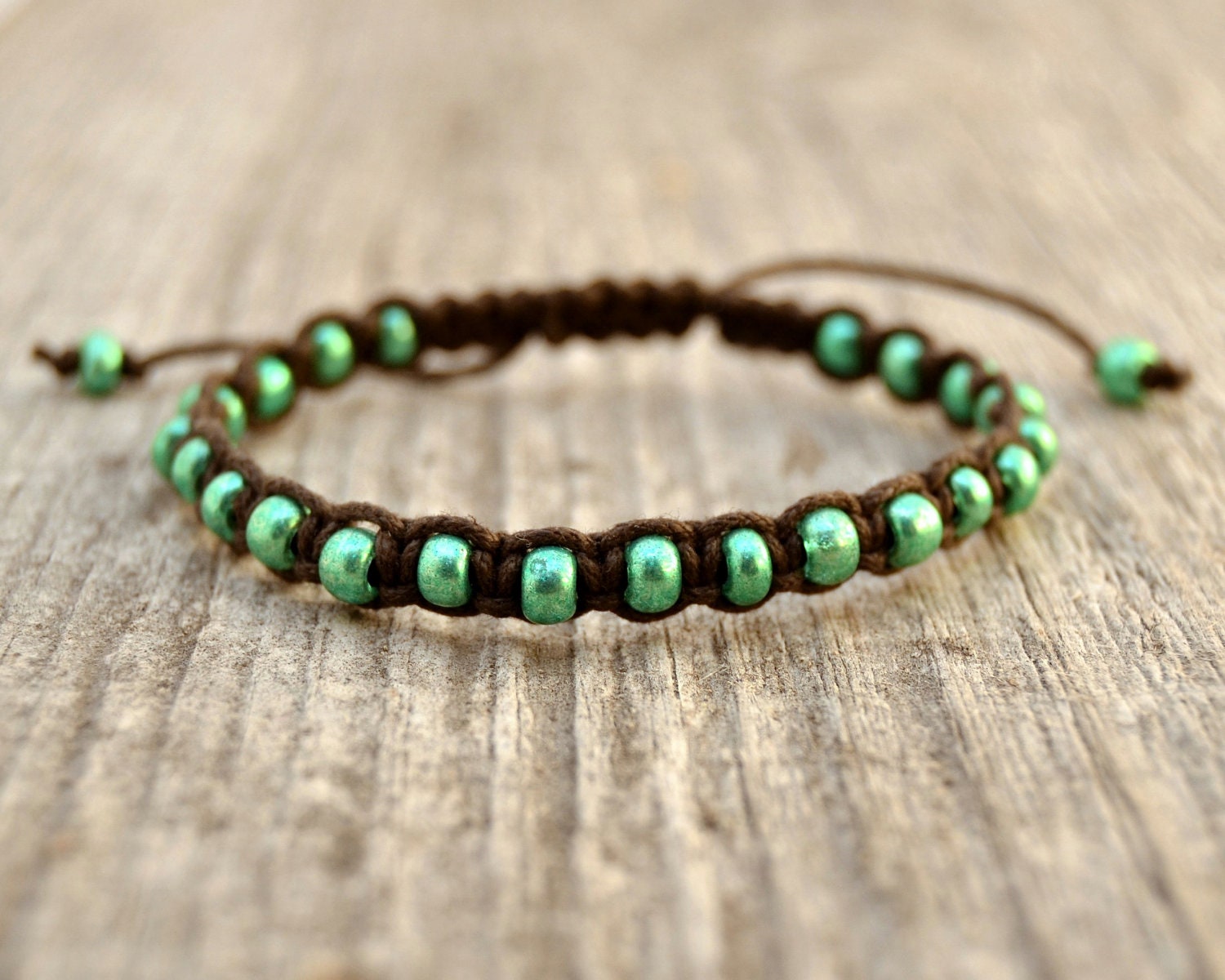 Beaded macrame friendship bracelet. Metallic green seed beads on bark brown waxed cotton