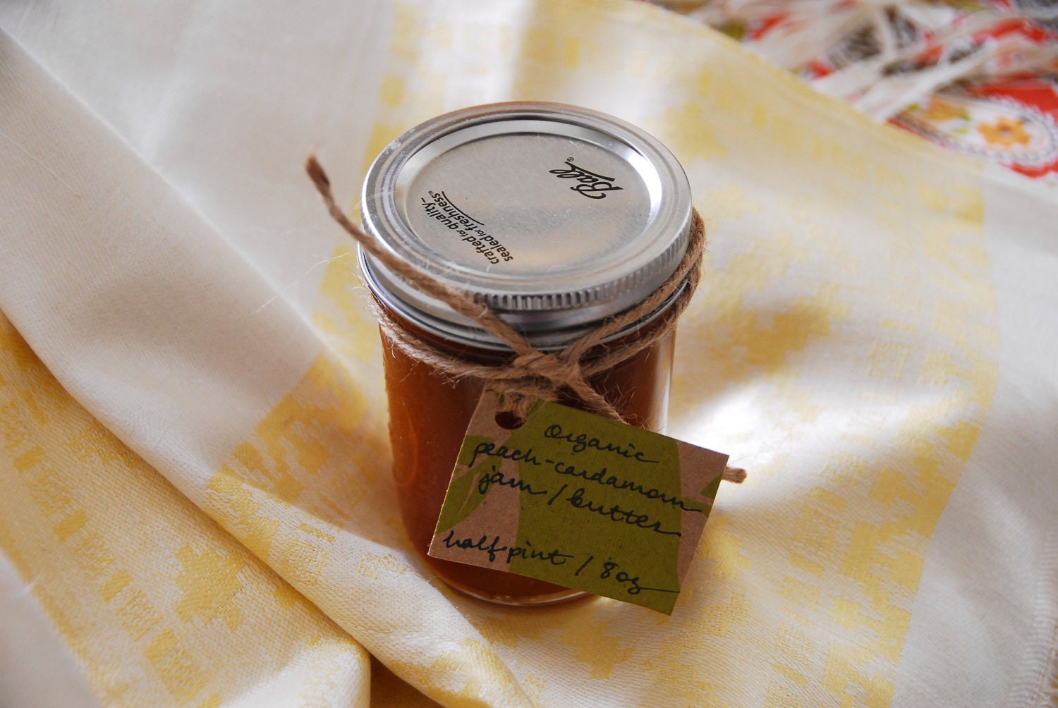 8 oz (half pint) jar of smooth organic peach jam / butter with ground cardamom and fair trade sugar