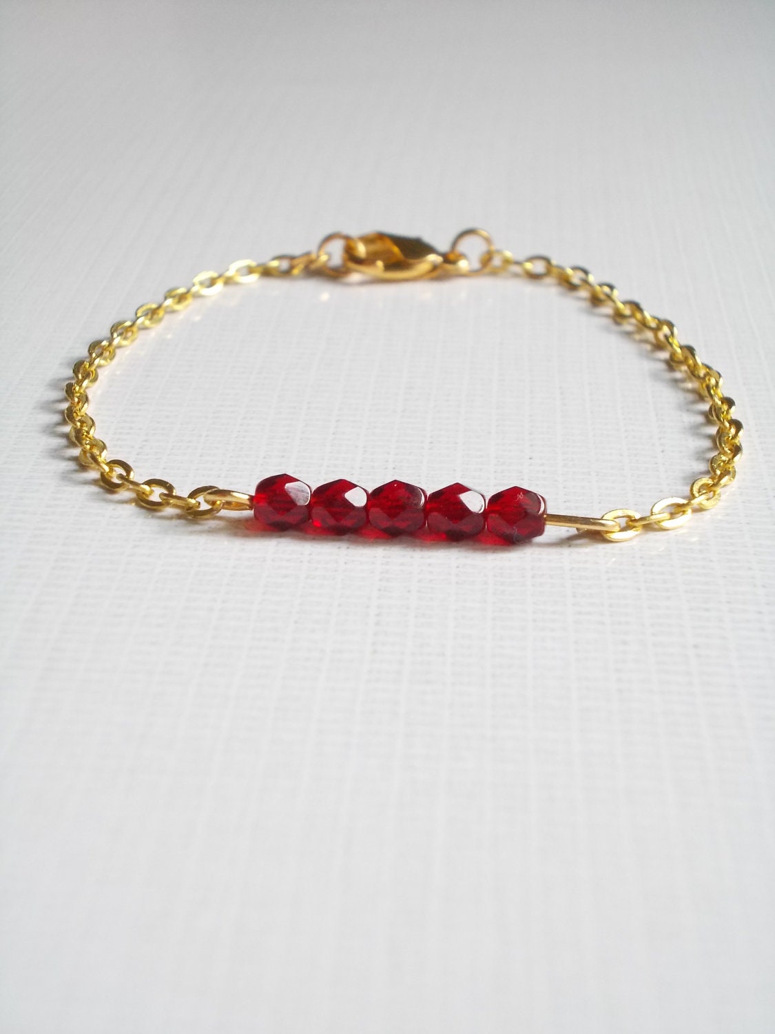 Red burgundy bracelet. Gold metal chain. Beaded bracelet.