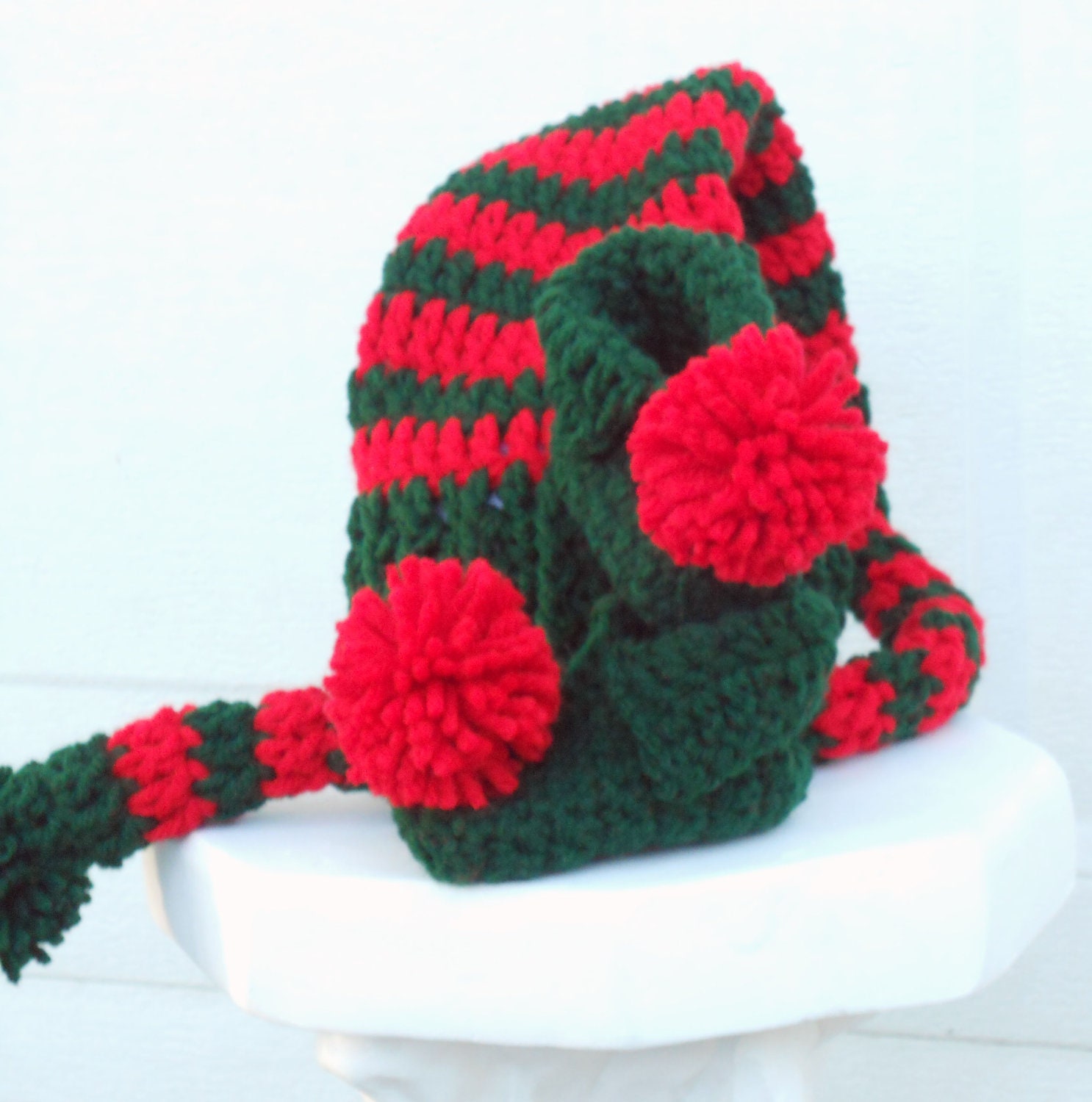 Crocheted baby pixie elf hat and booties set in green and red.
