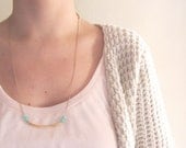 Geometric necklace. Minimal jewelry. Golden arc tube with aquamarine czech beads