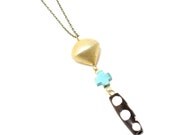 Leo -- polka dot black, white, gold, and turquoise cross necklace on brass chain
