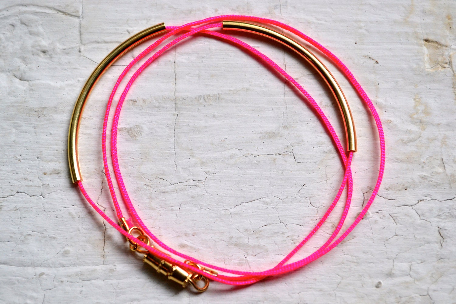 neon pink super skinny nylon triple wrap bracelet with two long gold tube