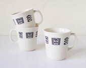 Three white mugs with geometric patterns
