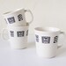 Three white mugs with geometric patterns
