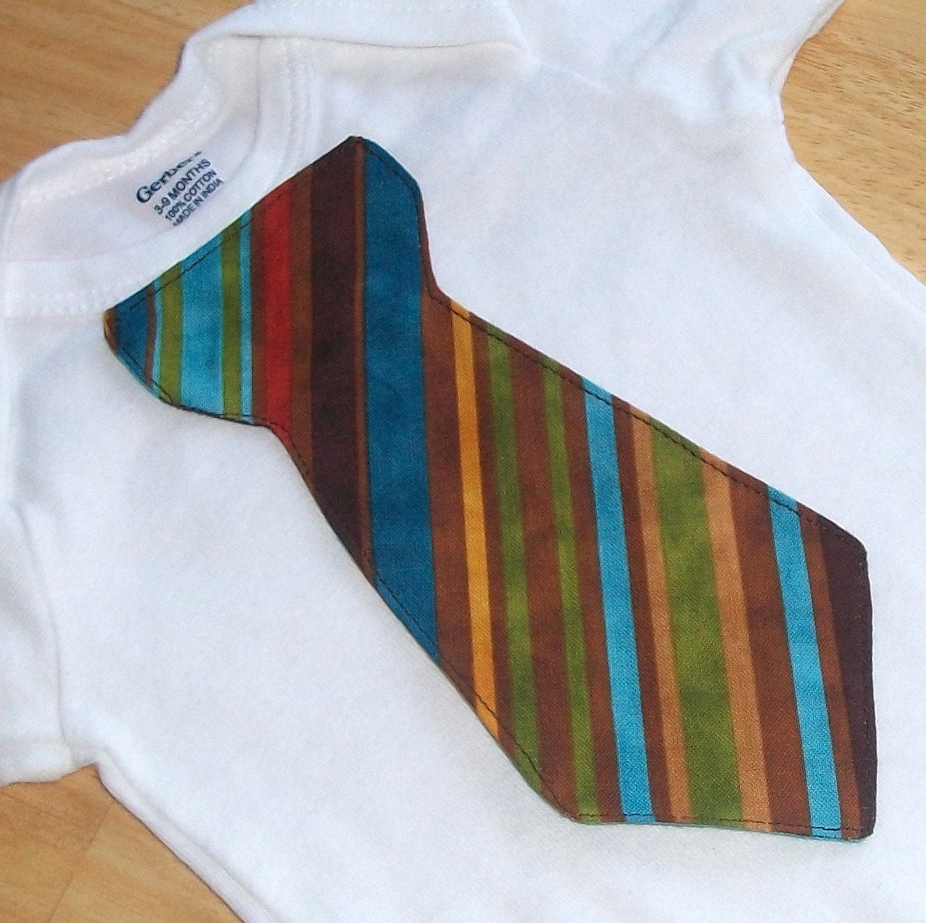 Baby tie onesie or shirt with green, brown, teal, aqua, and orange
