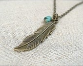 Antique brass feather necklace with a turquoise bead.  Jewelry by Sweet And Simple Jewelry Design.