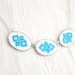 Hand embroidered necklace with three blue Ukrainian ornament in silvertone