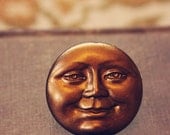sol.  a large copper sun face cab ring.