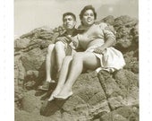 Woman shows off LEGS loving Couple sits on rocks photographer shoots from below 60s ish Vintage PHOTO