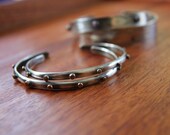 Two thin sterling cuff bracelets with hammered bronze studs