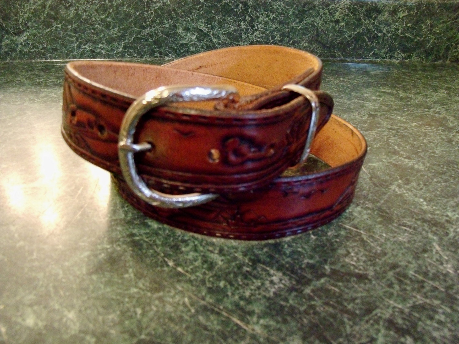 Custom made hand tooled leather belt with mountains to the sea theme.