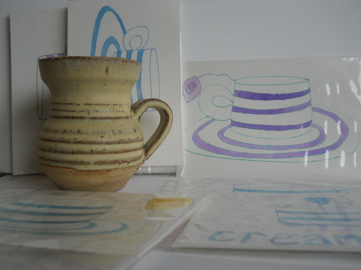 Wish you were here to take tea. Postcard of Cornish tea cup, coloured with inks.