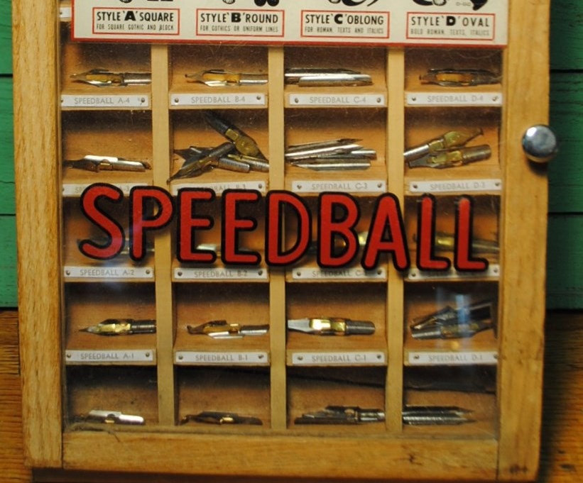 ANTIQUE PEN NIBS Speedball display case with glass top and 52 pen nibs wonderful for office, writer or artists studio.