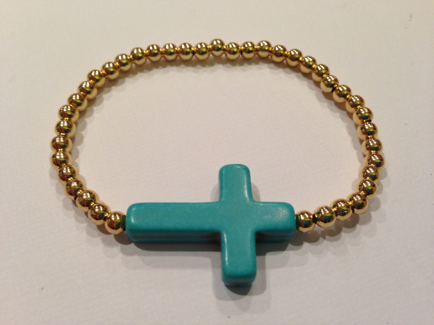 Sideways Turquoise Howlite Cross Gold Beaded Bracelet