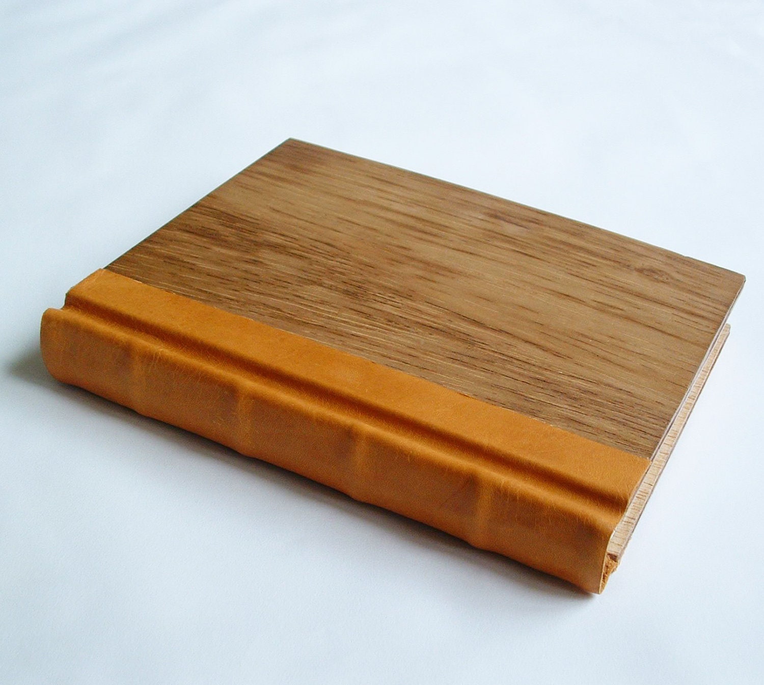 Beautiful handmade book, traditionally bound, hand-sewn, in warm wood and soft goatskin, with rounded spine.