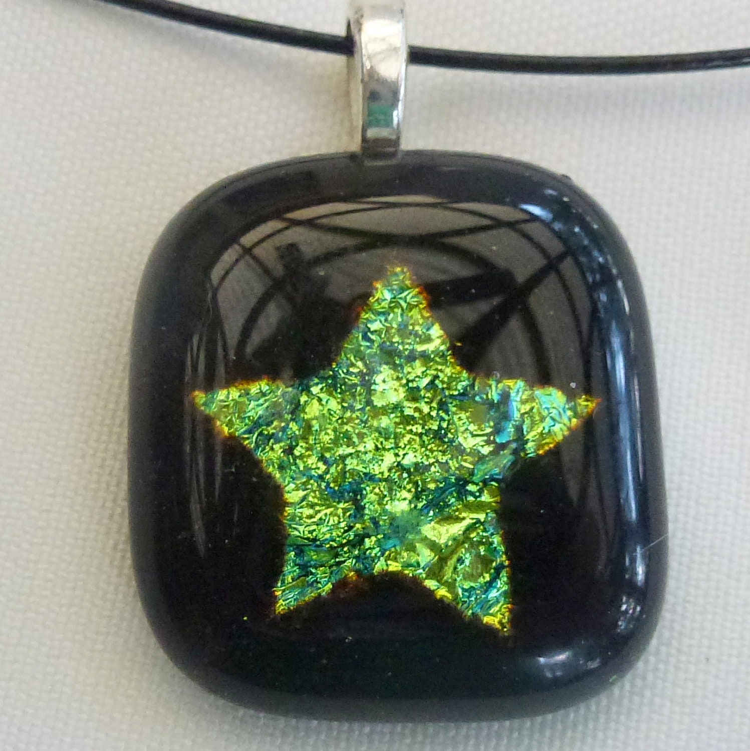 Green star dichroic glass pendant with a sterling silver plated bail on a black neckwire - LotsaShimmer
