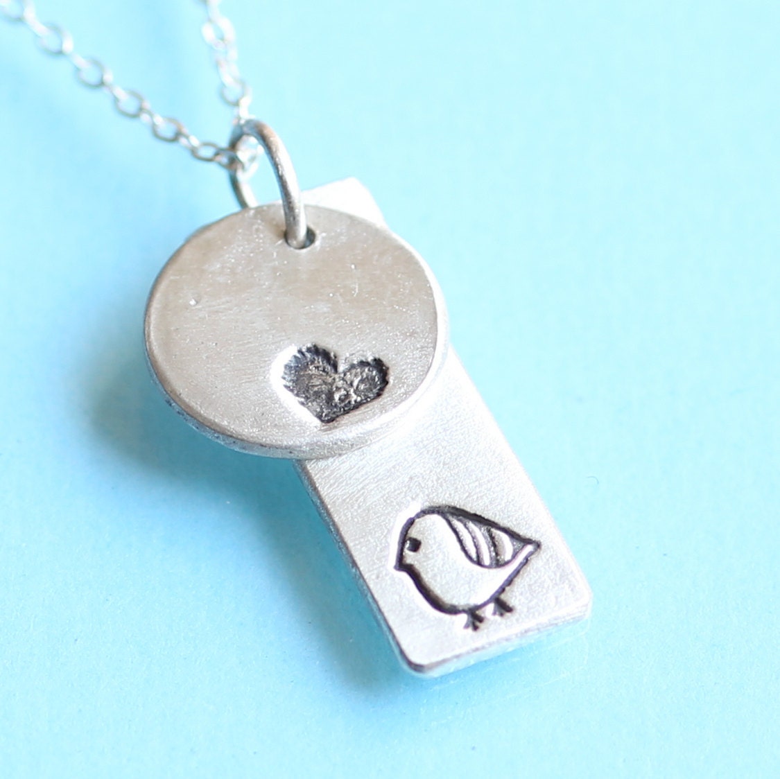 STRIPED BIRD and HEART necklace, double charm pendant, eco-friendly silver. Handcrafted by Chocolate and Steel