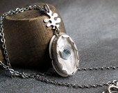 PENDANT sterling silver, oval watch crystal, linen, button, and fern bail