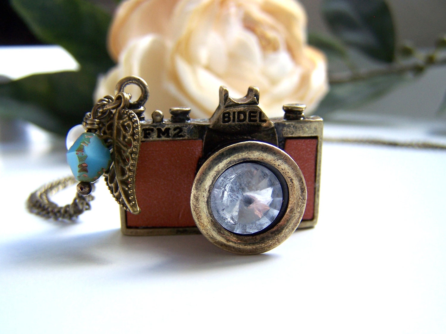 the tan leather camera necklace.