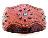 Lobed leather cuff / bracelet with turquoise and black glass bead inlay.
