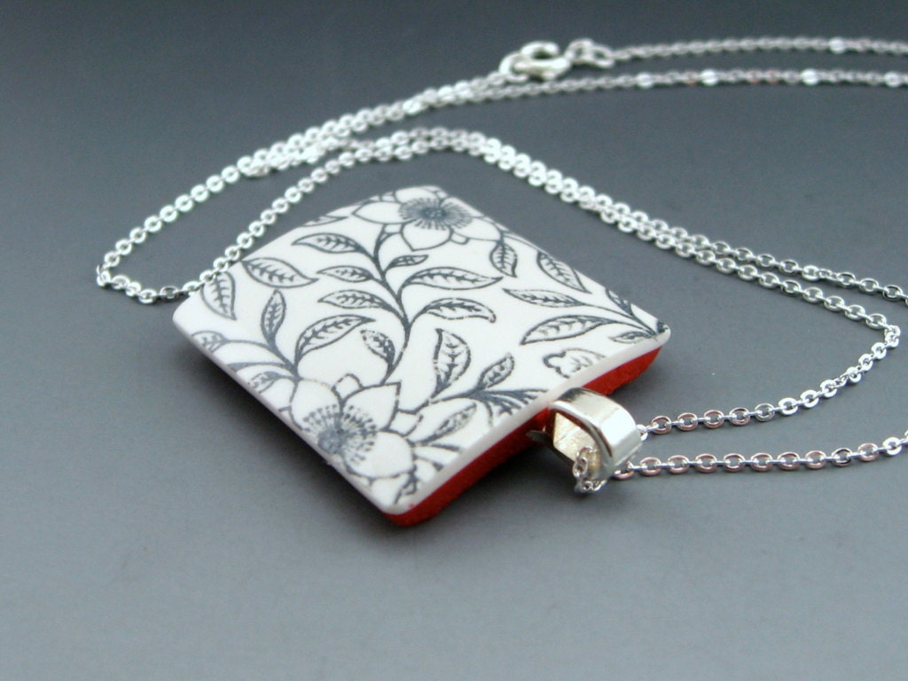Modern black and white polymer clay pendant necklace with traditional Asian flower motif and a pop of color