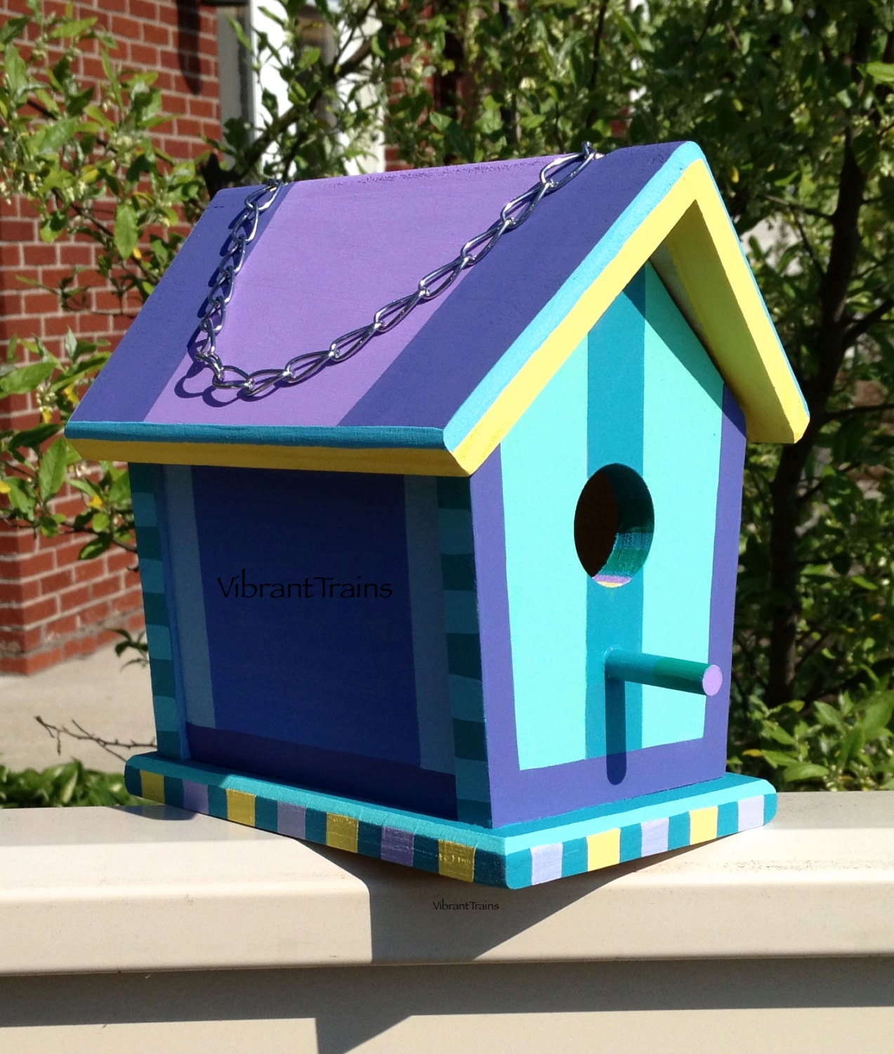 Sturdy wood birdhouse with removable top for cleaning and maintenance in purple teal and yellow
