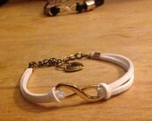 White faux suede w/gold infinity symbol
