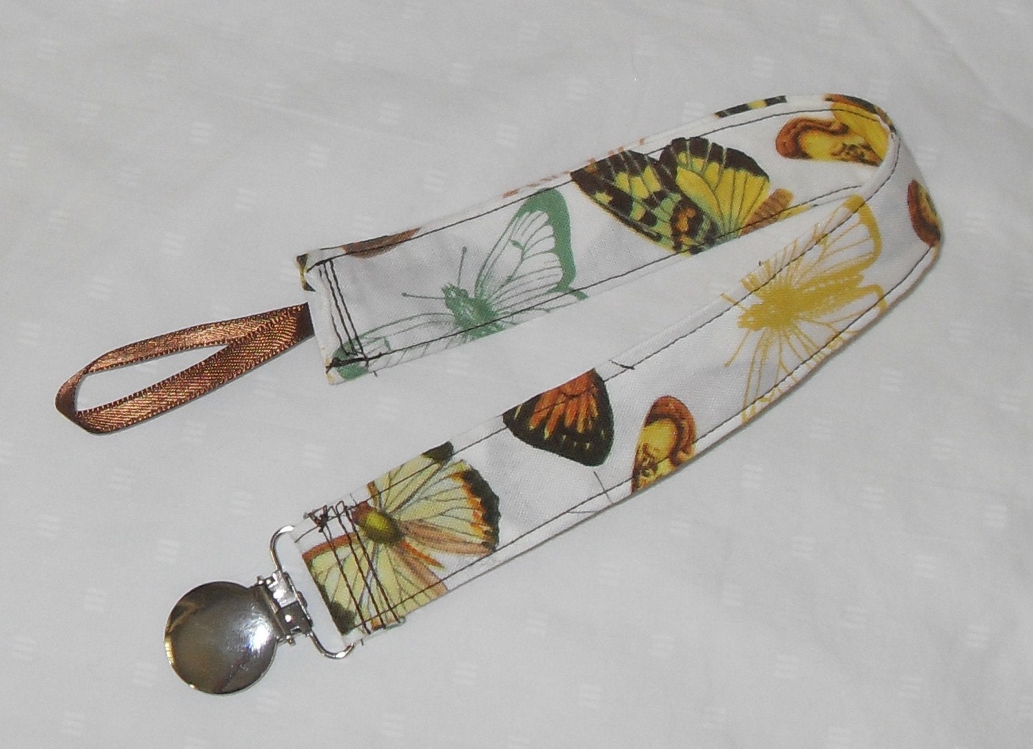 French Journal Anjou Papillon in White Pacifier Clip