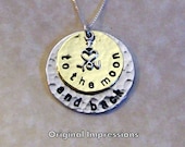 I love you to the moon and back pendant necklace of hammered brass and aluminum with a sterling silver charm on a sterling silver chain.