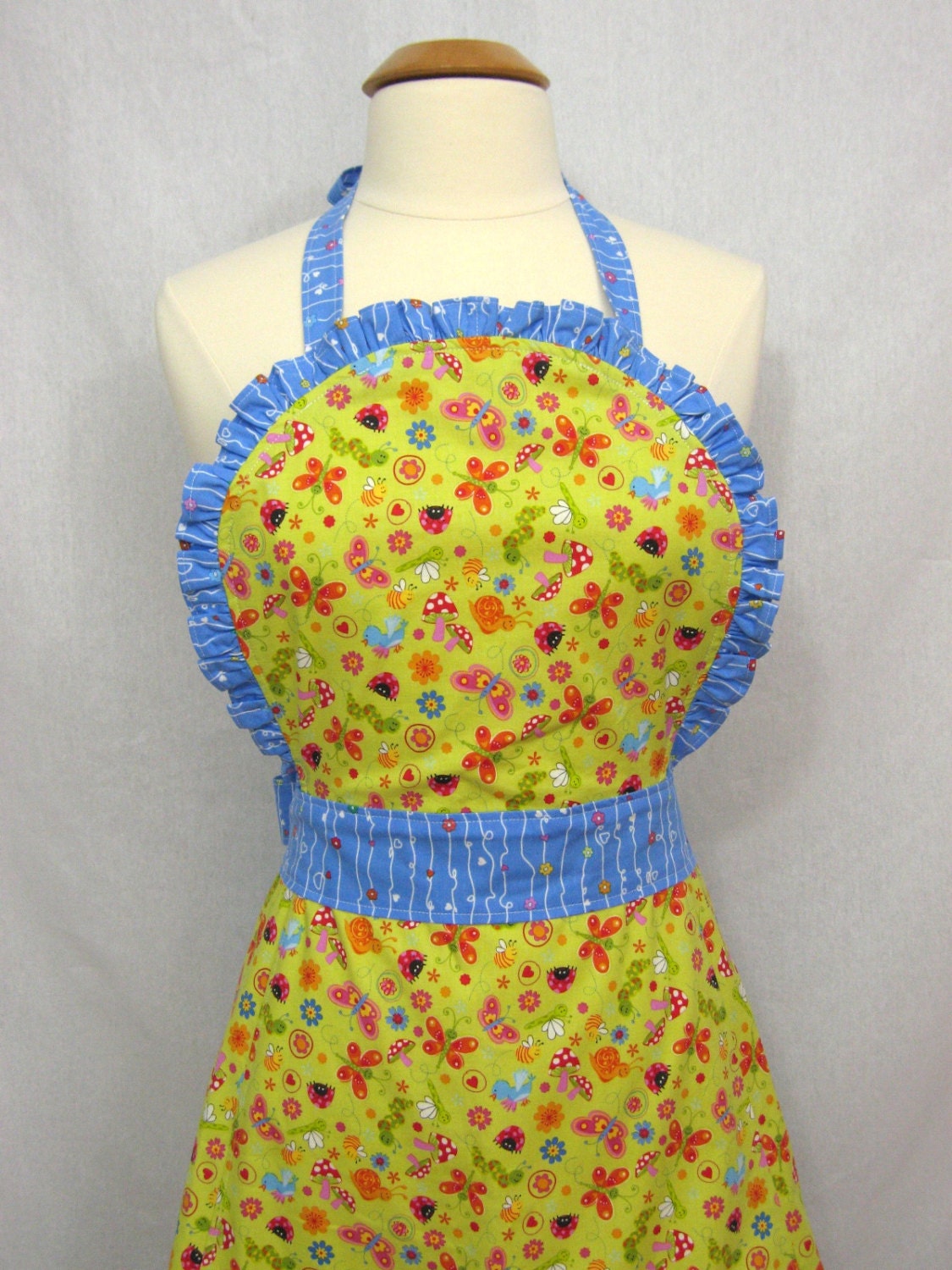 Ruffled Apron with Ladybugs, Butterflies, and Mushrooms on a Lime Background - Henley Studio fabric