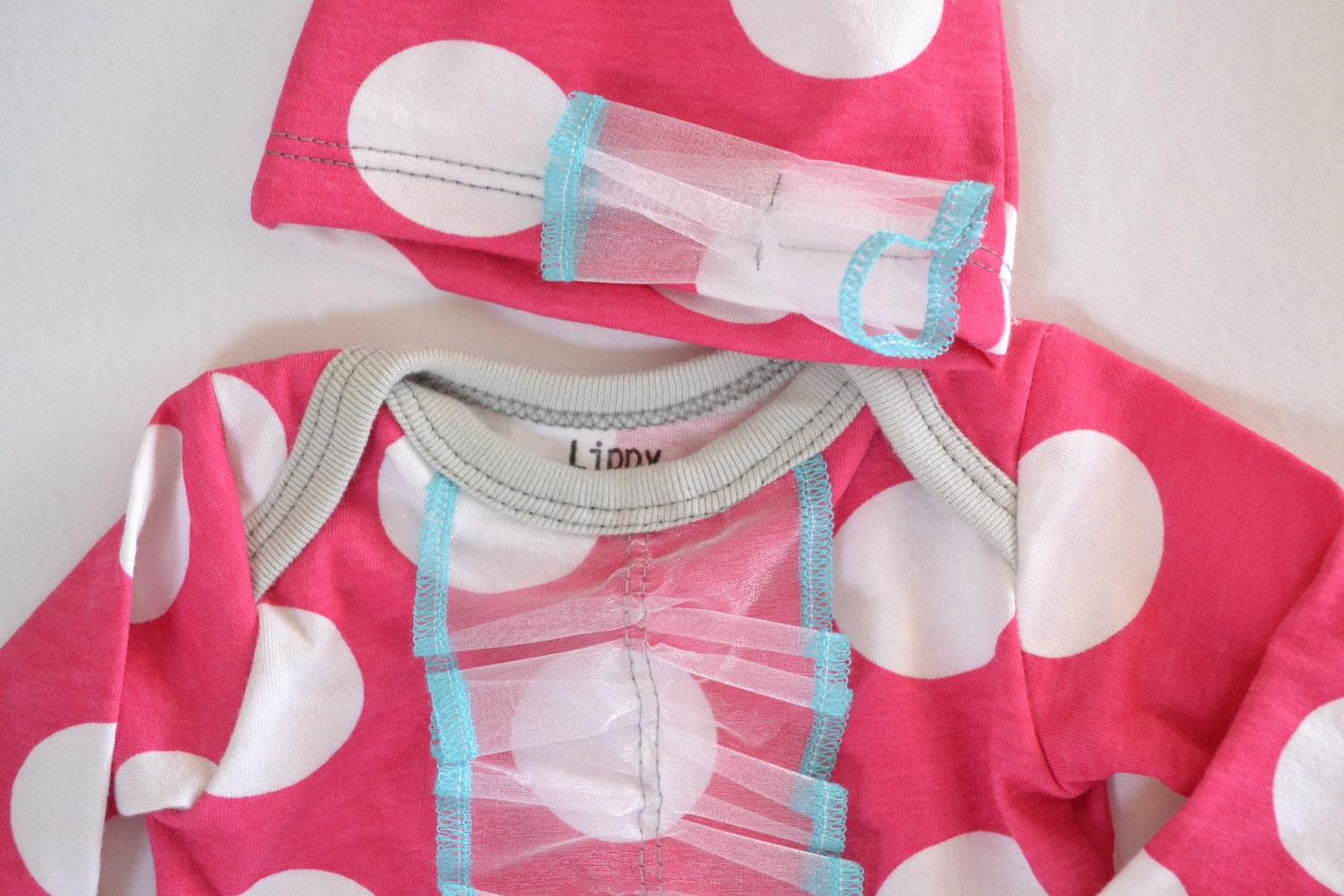 Baby girl outfit. Size- newborn. Colors- pink and white polka dots, with blue and gray trim.   (By lippybrand)