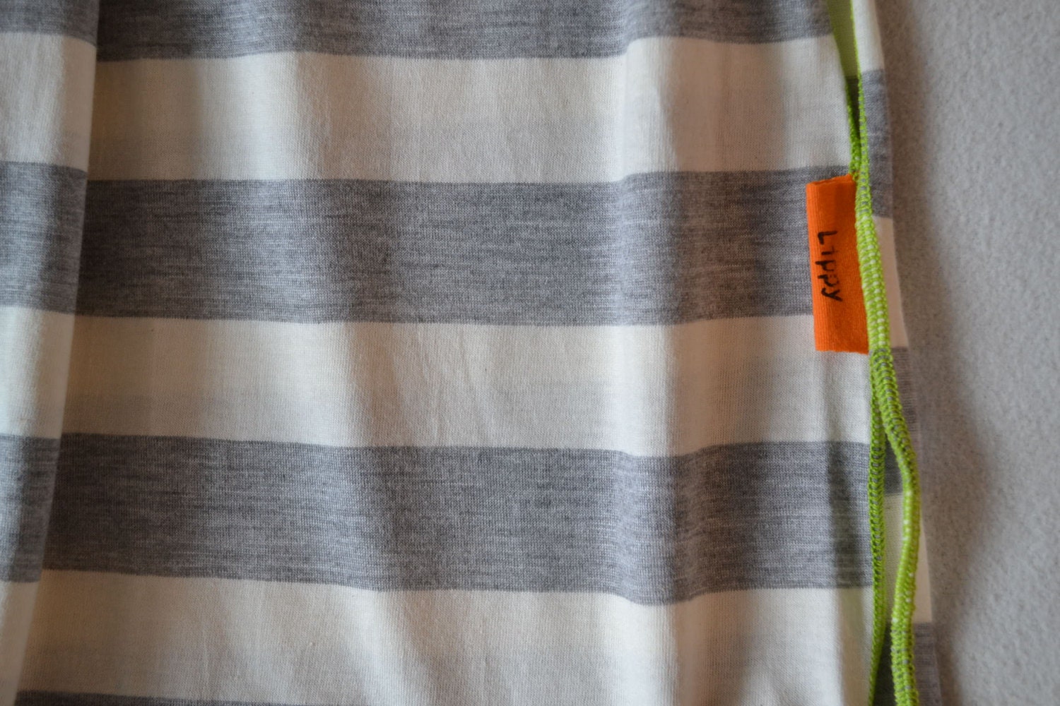 Striped swaddle blanket. Soft and stretchy.  Size 31 by 40 inches. Colors- gray and cream with green edging.   Made by lippy brand.