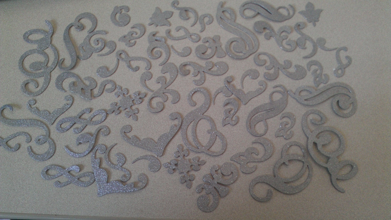 Glittery silver Chipboard flourish accents (53 pieces)