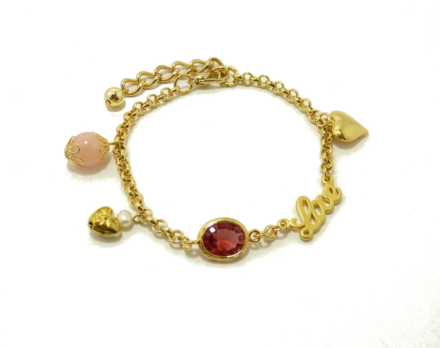 Single strand charm bracelet with 16K gold-plated charms in rose pink color.  By Simply Uniq