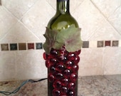 Wine bottle with lights and red Grapes