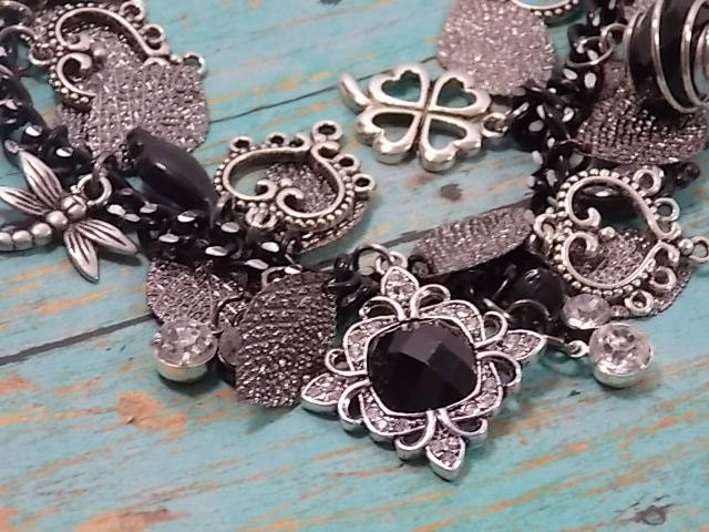 Black and White charm bracelet, black onyx & rhinestone centerpiece, black glass beads, crystal teardrop, dragonfly and 4-feaf clover charms