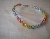 This bracelet is 7 1/2 inches long and has rainbow colored beads on a hemp cord with a silver colored metal lobster claw clasp