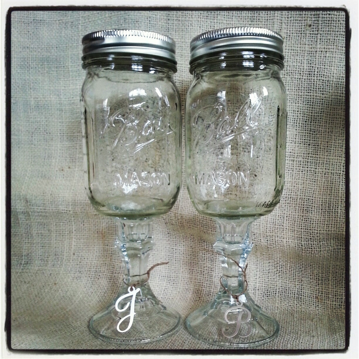 A pair (2) 16oz Mason Jar wine glasses with initial charms.